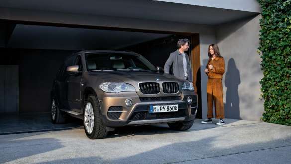 BMW Value Service BMW Value Service ผู้ชายและผู้หญิงยืนอยู่บนถนนถัดจากรถยนต์ BMW